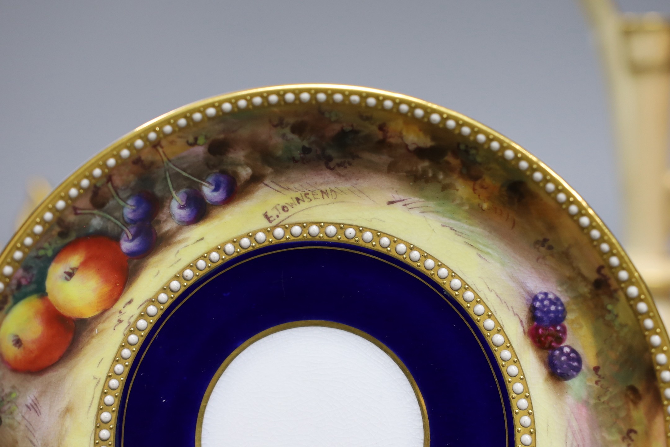 A pair of Royal Worcester blush ivory ewers, a similar vase and a beaded saucer decorated by E. Townsend, saucer 13.5cms diameter